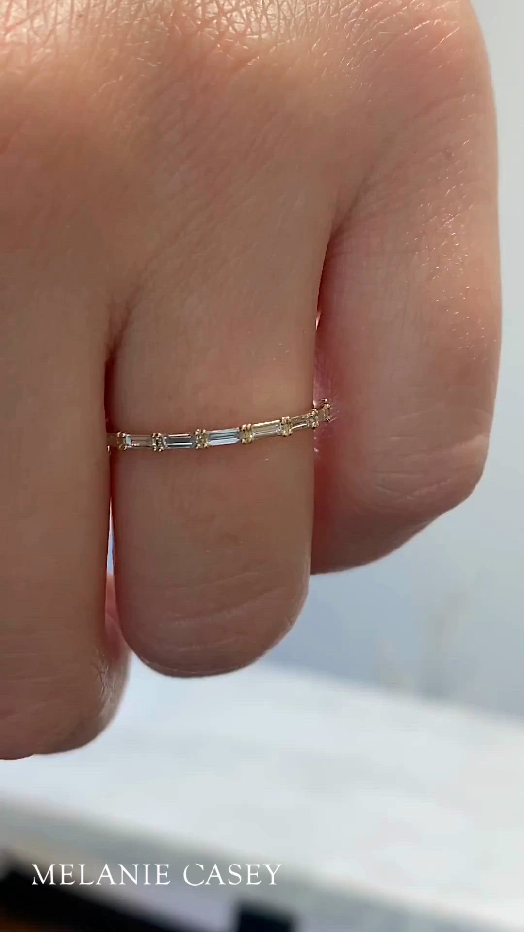 This contains: A woman's hand wearing a dainty diamond band.