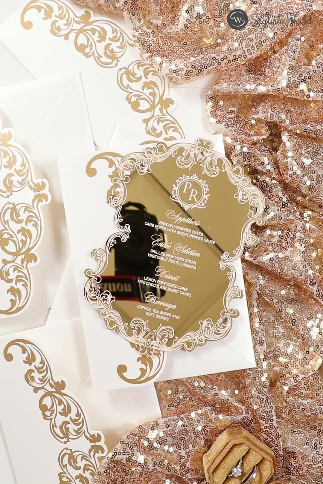 This may contain: wedding stationery with gold foil on white paper and golden sequins around it