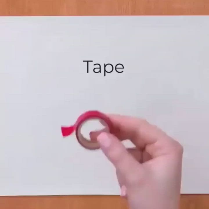 This may contain: a person holding a pair of scissors in front of a piece of paper with tape on it