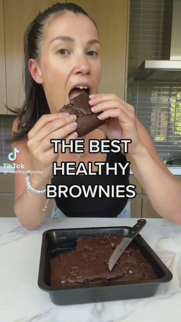 This may contain: a woman is eating a chocolate brownie with the words, the best healthy brownies