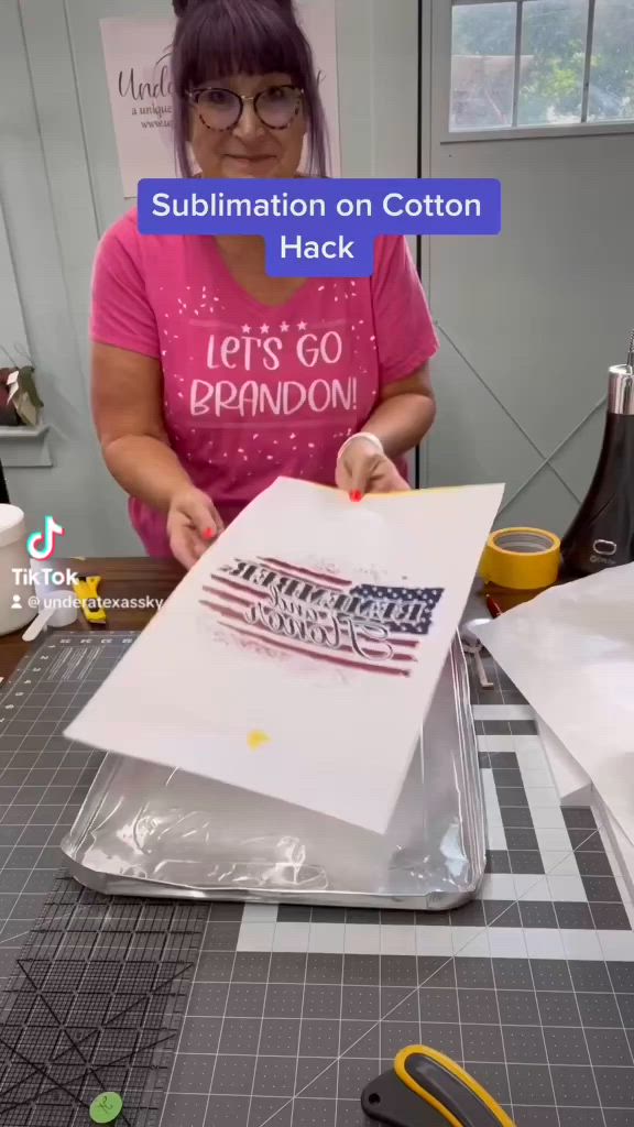 This may contain: a woman is cutting out an american flag on a piece of white paper with scissors