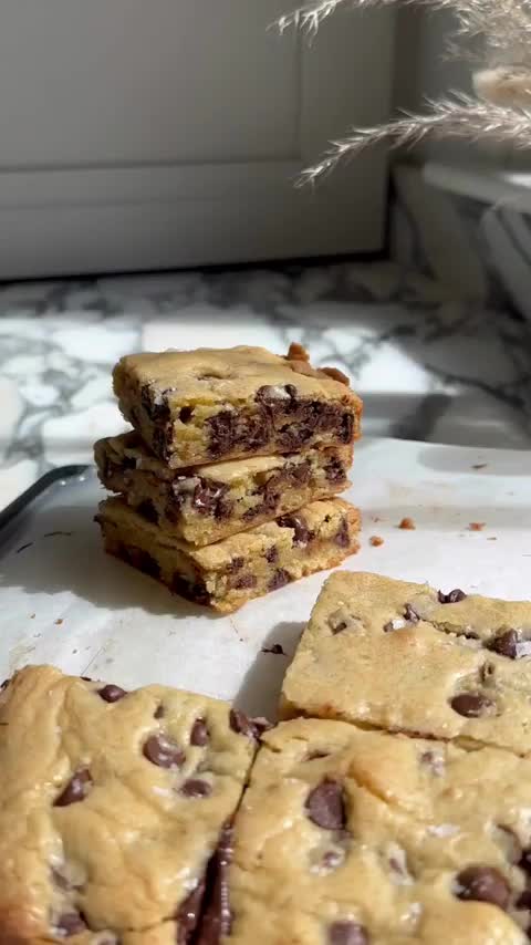 This may contain: chocolate chip cookie bars stacked on top of each other