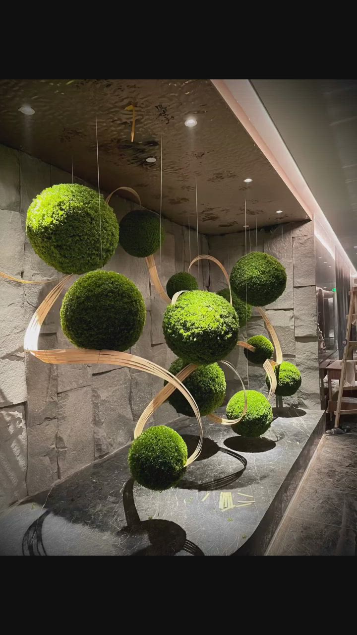 This may contain: some green plants hanging from the side of a wall in a room with stone walls