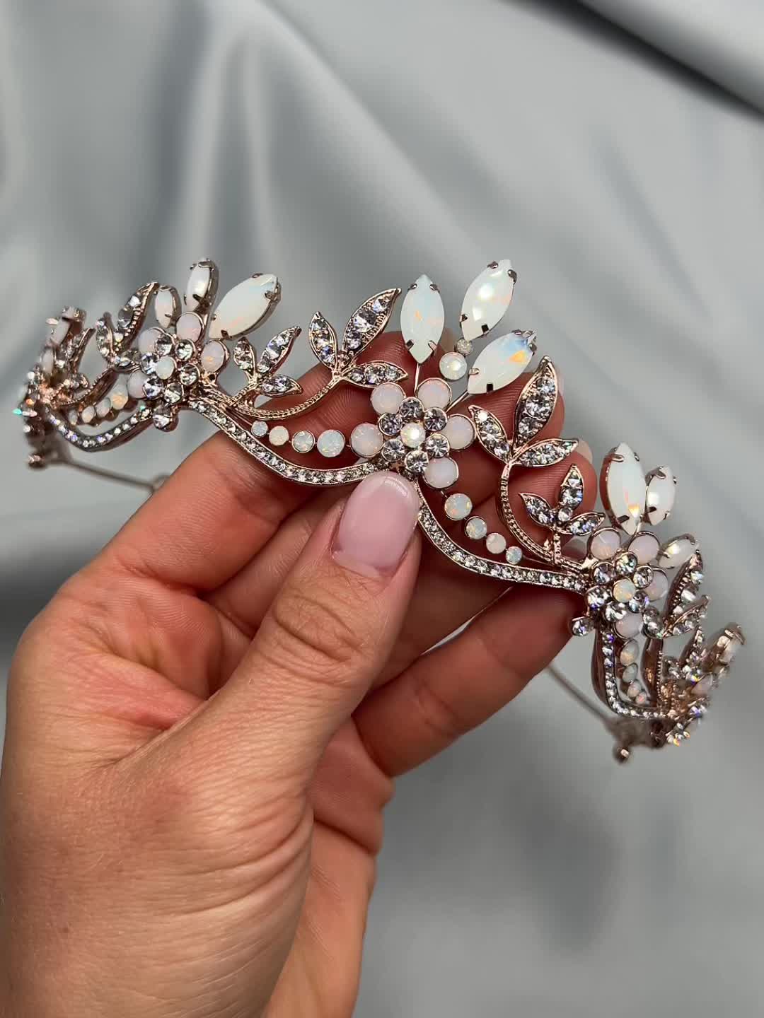 Steal the spotlight with our Jolie Opal Crown. Elegantly crafted with opal gemstones & crystals, Jolie will make you feel like a princess on your wedding day. Surprisingly lightweight! Designed with opal and crystal gemstones. Measures 1.5 inches at center peak. Pin loops are located at each end so you can secure in your hair with bobby pins, if needed. Style #3378