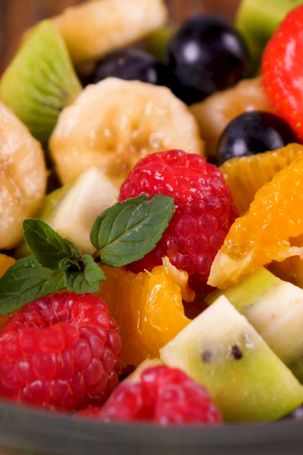 This may contain: a close up of a bowl of fruit with the words delicious raspberry salad recipe