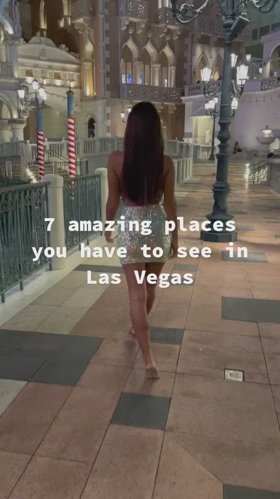 This may contain: a woman walking down the street in las vegas with text overlay that reads, 7 amazing places you have to see in las vegas