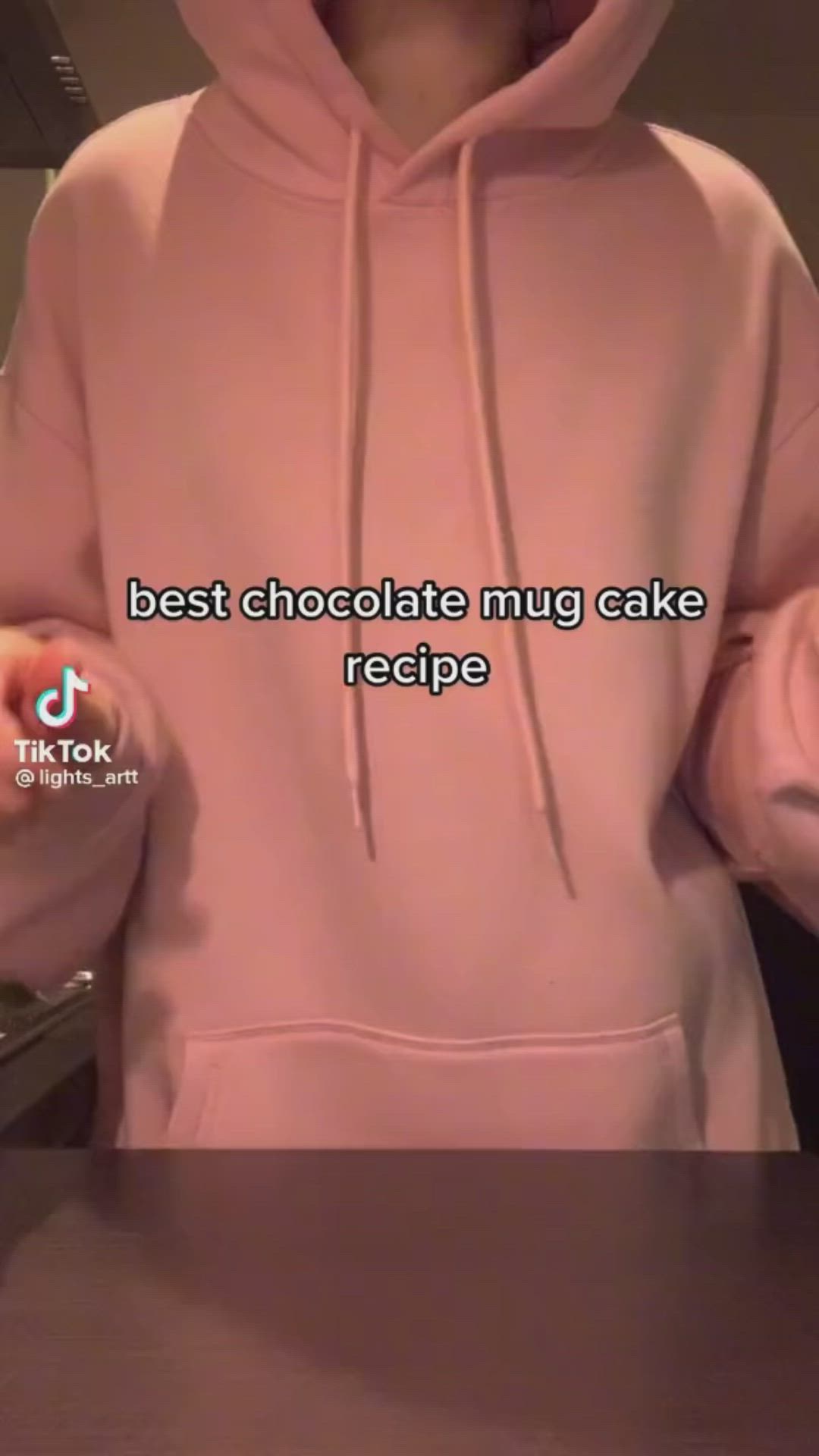 This may contain: a person wearing a pink hoodie with the words best chocolate mug cake recipe