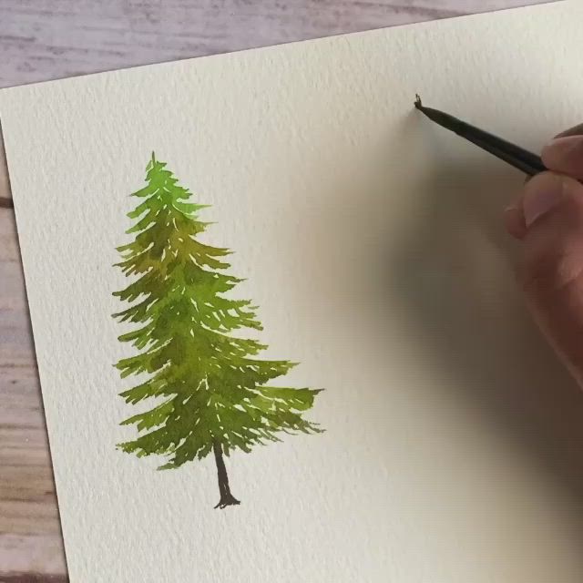 This may contain: someone is drawing some trees on paper