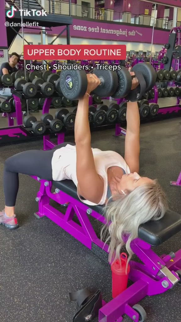 This may contain: a woman is doing exercises on a bench in the gym with dumbbells behind her