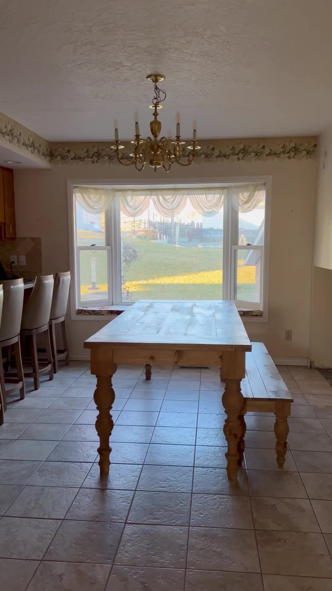 This may contain: a dining room table in front of a large window