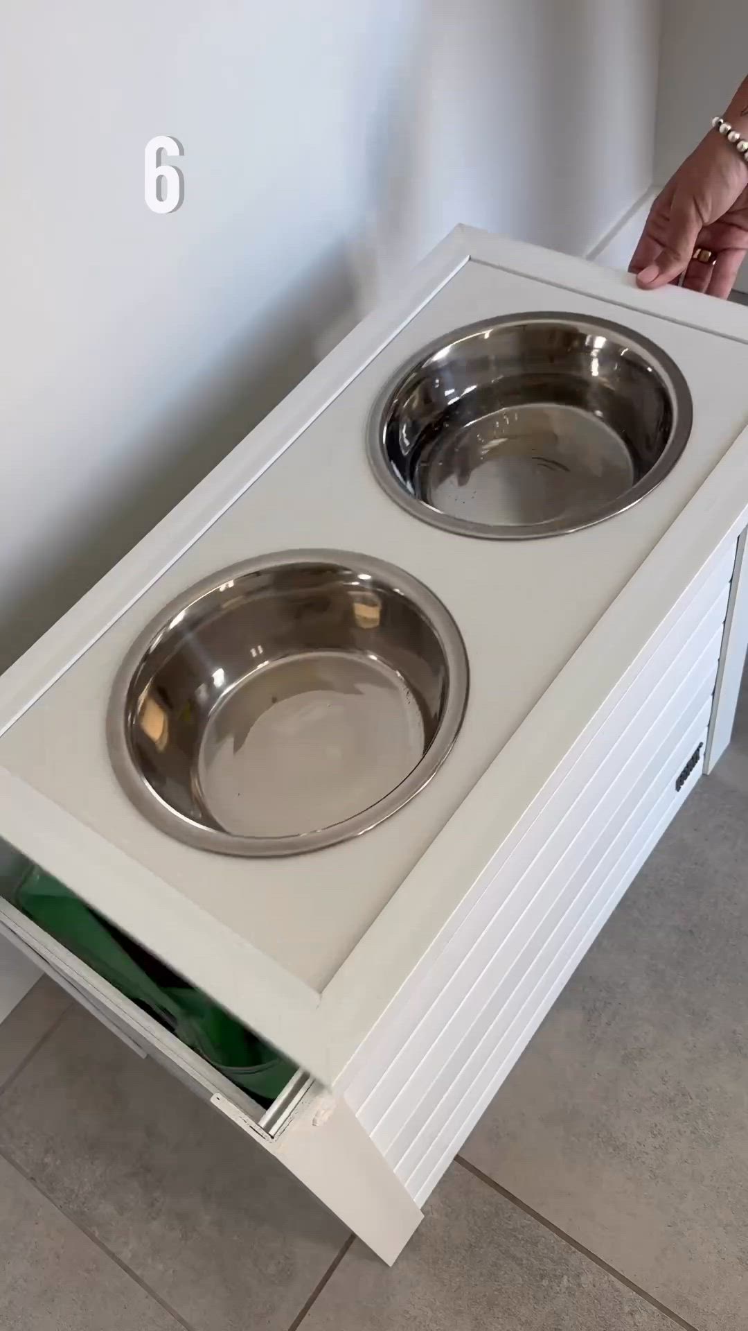 This may contain: a dog food tray is opened to reveal a water bowl