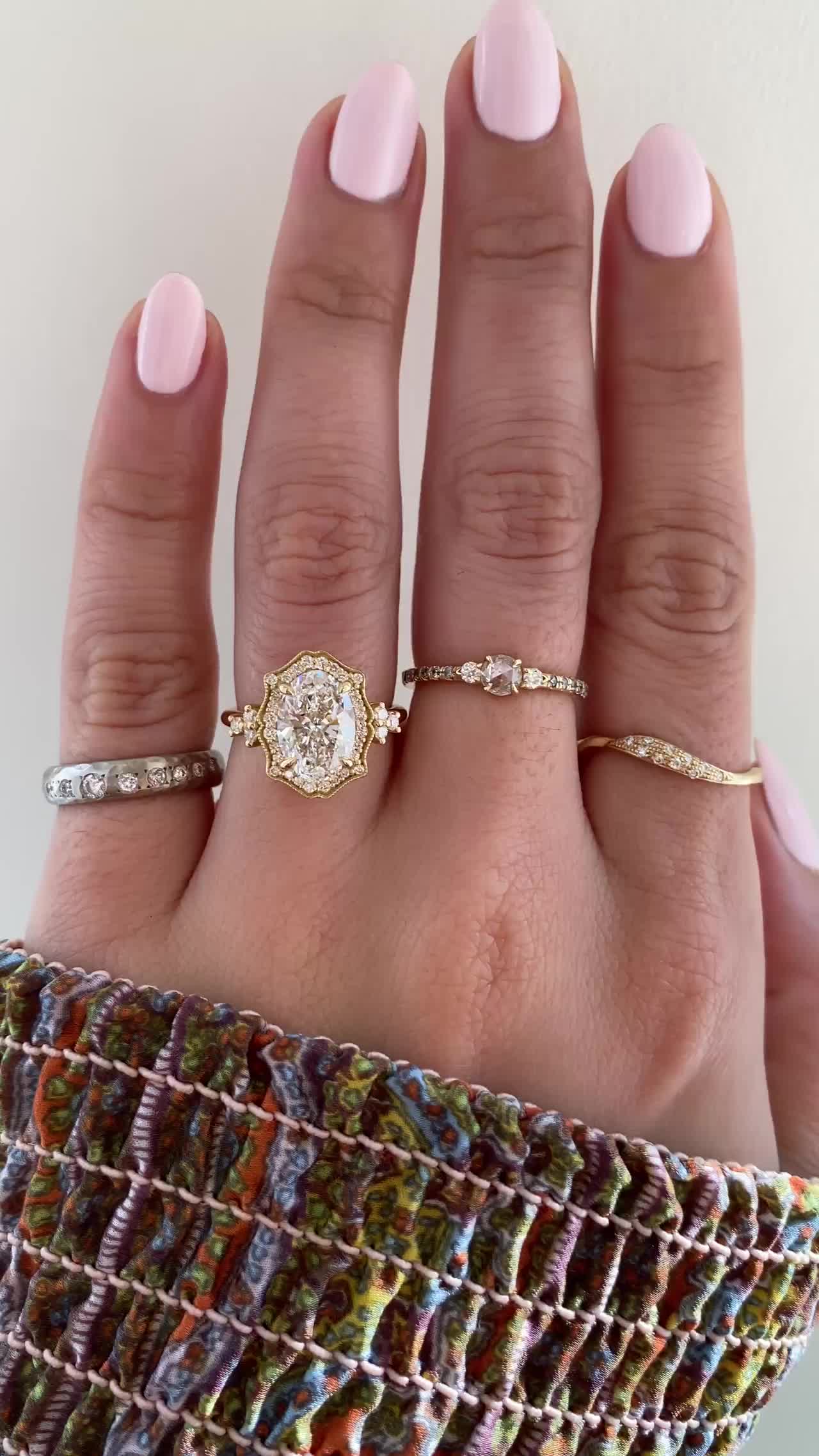 This may contain: a woman's hand with three different rings on her fingers and one is wearing a ring