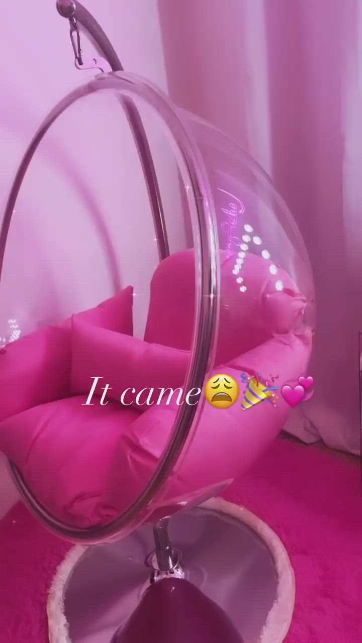 This may contain: a bubble chair with pink cushions in a room