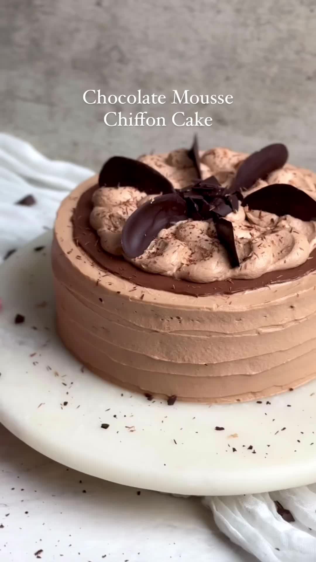 This may contain: a chocolate mousse cake on a white plate