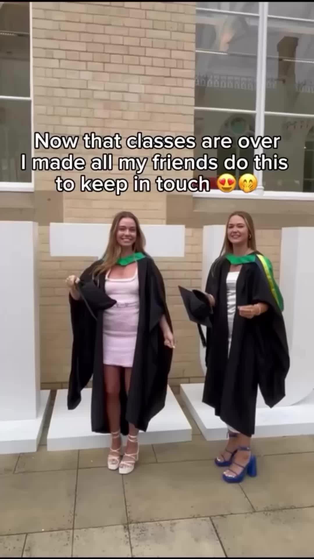 This may contain: two women in graduation gowns standing next to each other