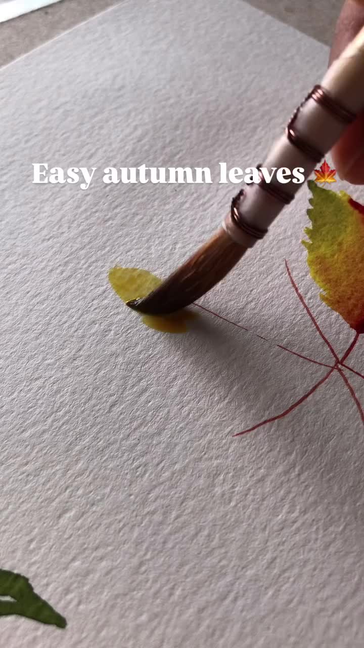 This may contain: a watercolor painting of a leaf on white paper