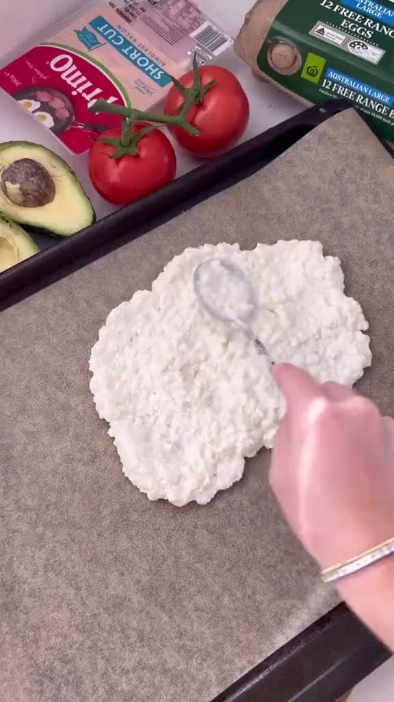 This may contain: someone is using a knife to cut up food on a cutting board with avocado and tomatoes in the background