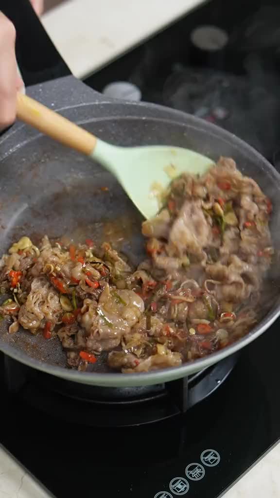 This may contain: a person stirring food in a pan on the stove