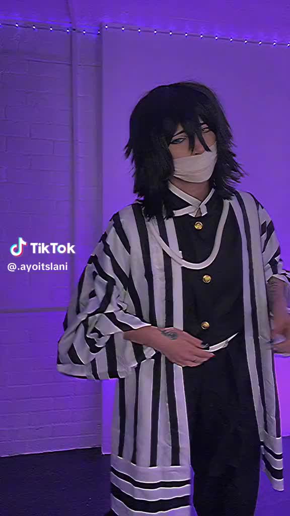 This may contain: a man dressed up as a jail inmate in front of a purple wall with the words tiktok on it