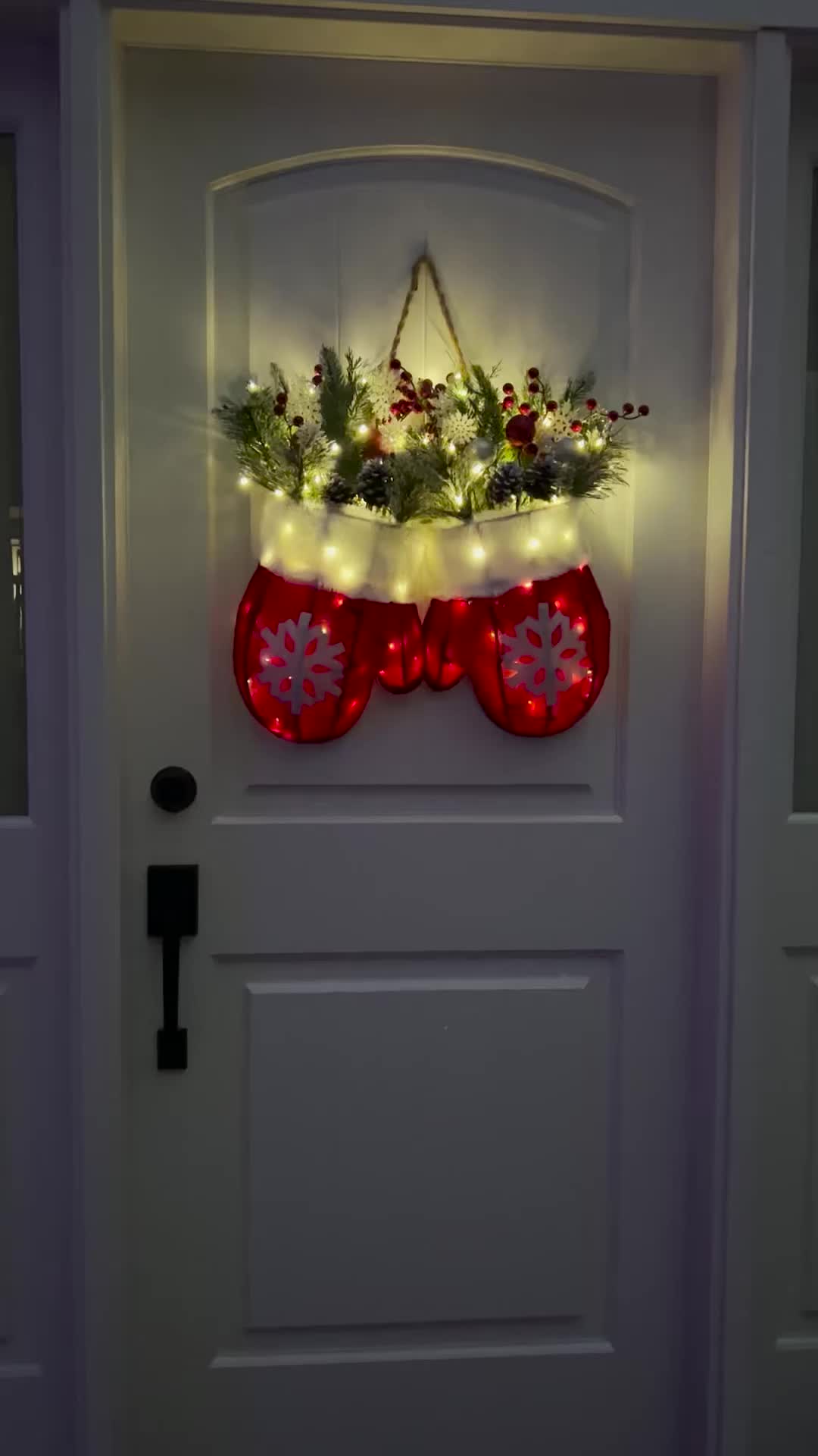 This may contain: a door decorated with christmas stockings and lights