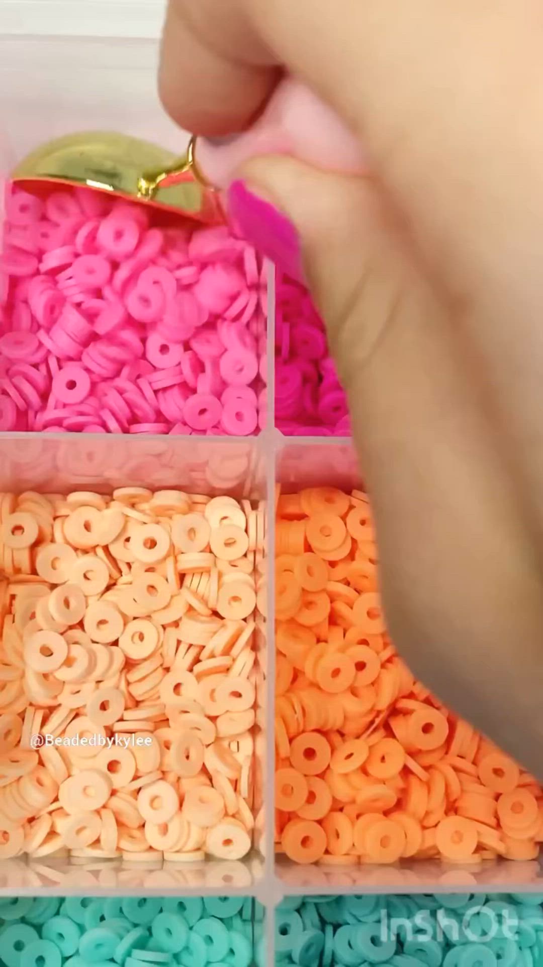 This may contain: a person is holding some pink and orange beads