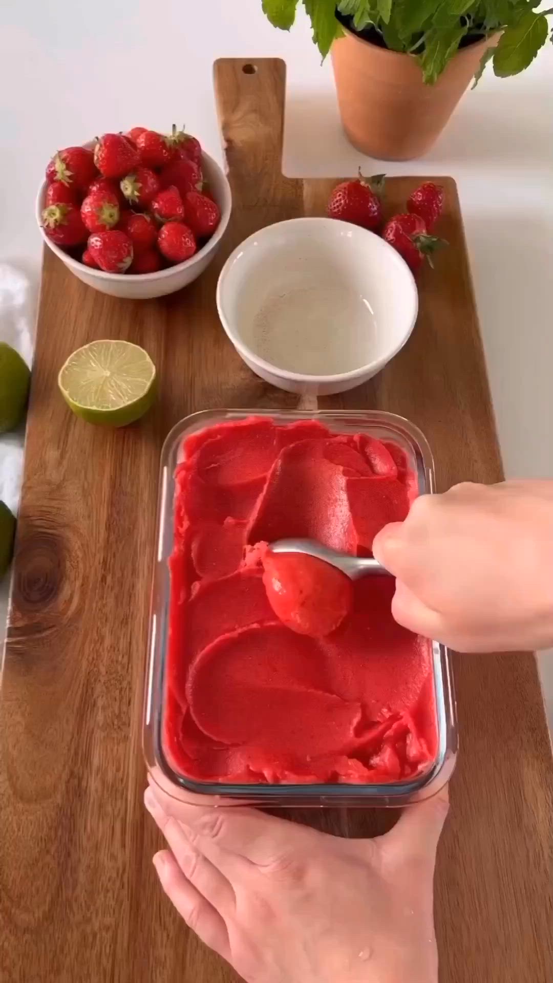 This may contain: a person is cutting strawberries on a wooden board