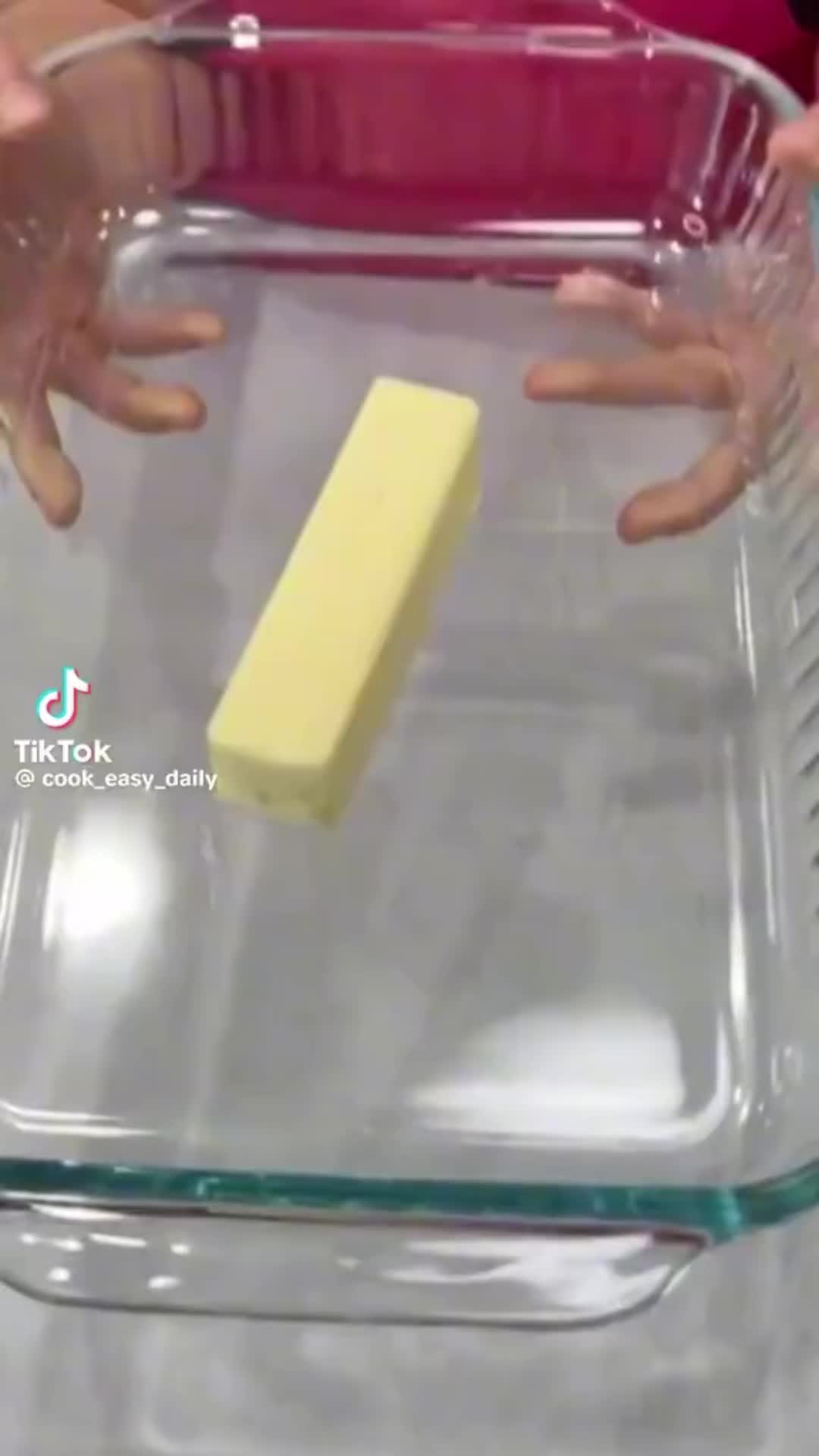 This may contain: two hands reaching for a sponge in a glass dish