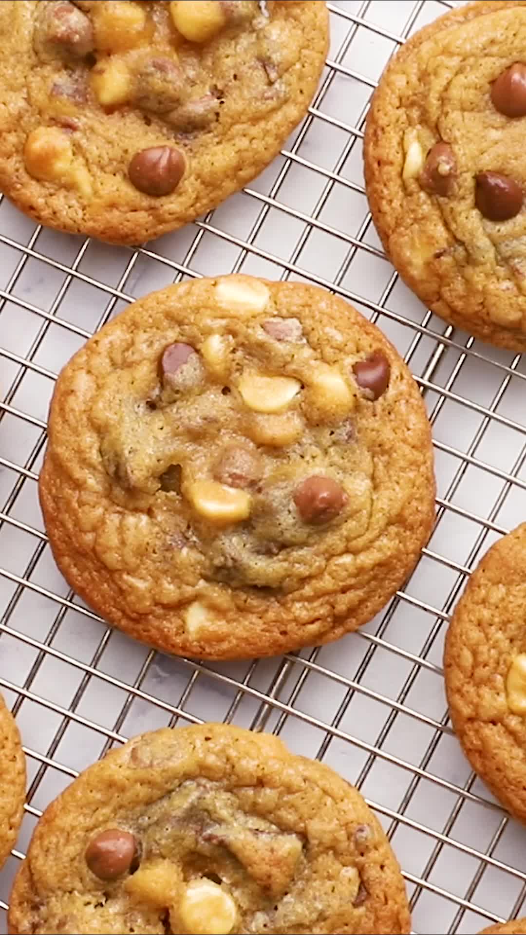 This may contain: a person holding up a chocolate chip cookie