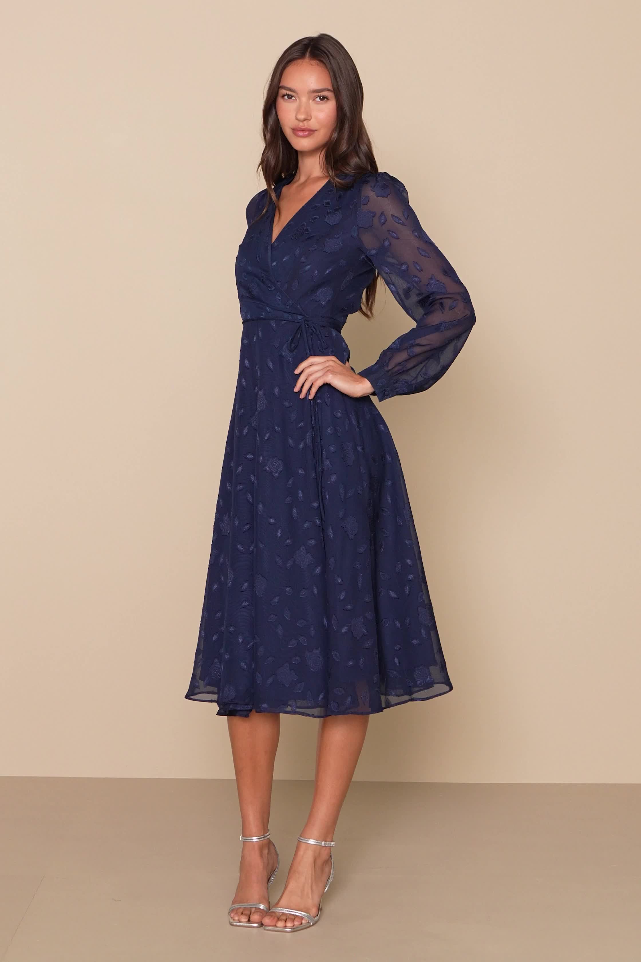 Classy and chic come together in perfect harmony to create the Lulus Evening of Elegance Navy Blue Floral Jacquard Wrap Midi Dress! Lightweight woven fabric, with a floral jacquard pattern, shapes this fabulous dress that has a surplice neckline and sheer long sleeves with button cuffs. Adjustable wrap silhouette, with tying waist sash and hidden internal ties, ends at a slightly ruffled midi hem. Fit: This garment fits true to size. Length: Mid-calf length. Size medium measures 47" from shoulde