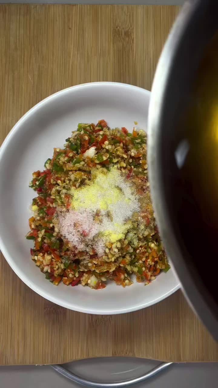 This may contain: a bowl filled with food sitting on top of a wooden table next to a person's hand