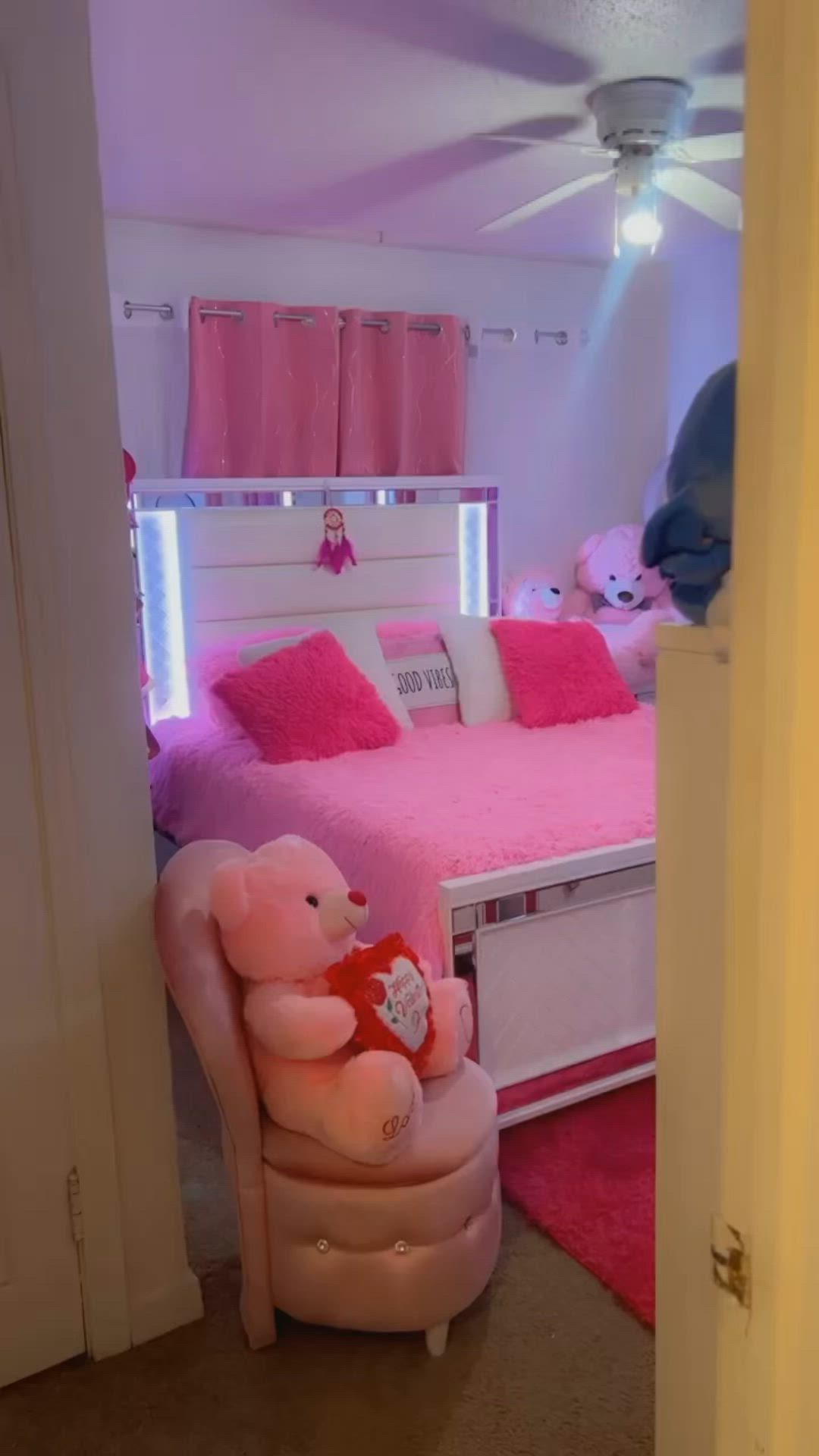 This may contain: there is a pink teddy bear sitting on a chair in the room that's decorated