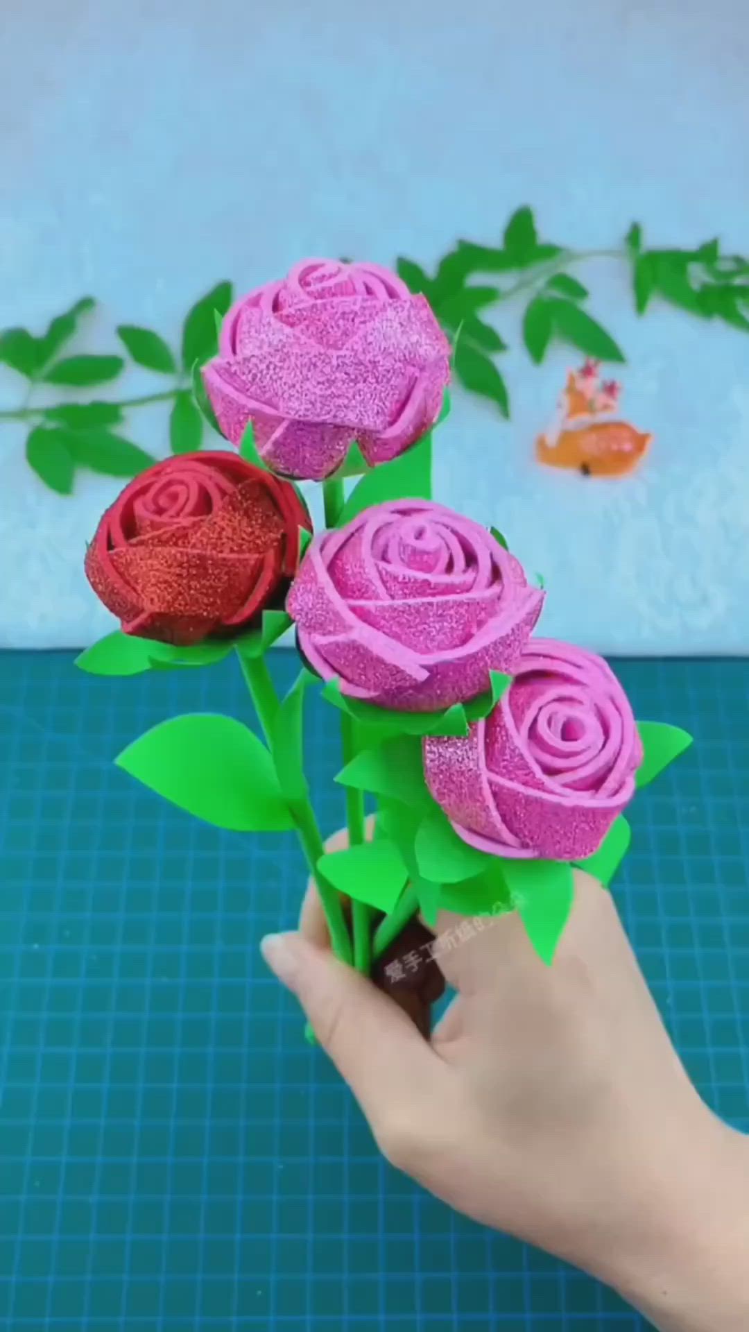 This may contain: someone is holding three paper roses in their hand