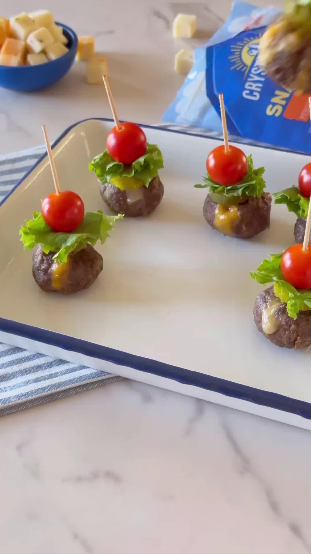 This may contain: small appetizers with tomatoes, lettuce and cheese are on a tray