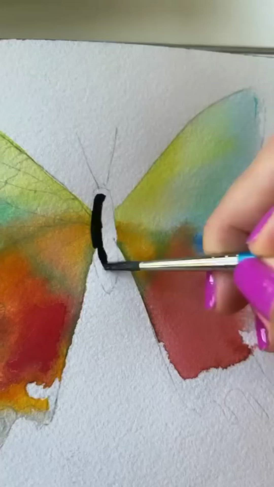 This may contain: a woman is painting some bugs on a piece of paper with watercolors and paintbrushes