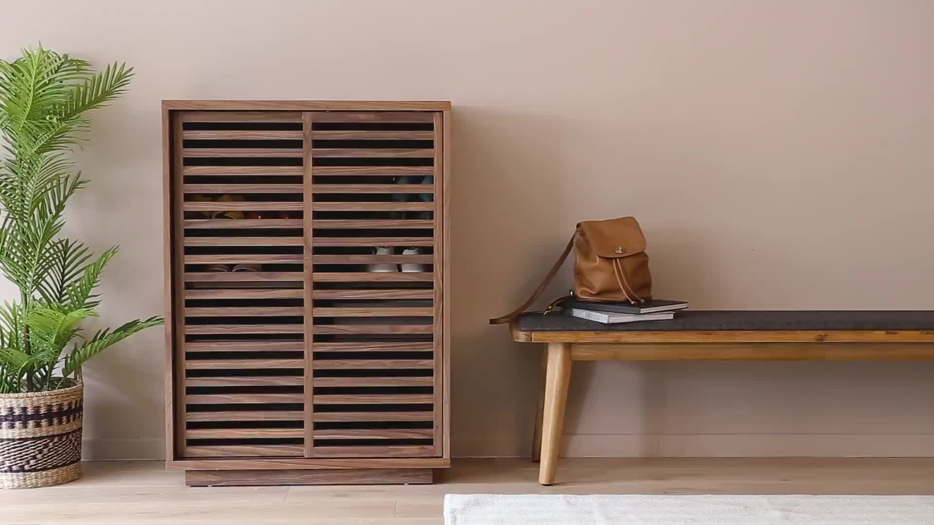 This may contain: a wooden cabinet sitting next to a table with a plant in it and a book on top