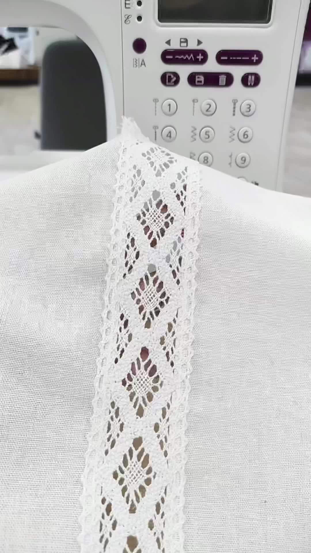 This may contain: a white piece of cloth with crochet on it next to a sewing machine