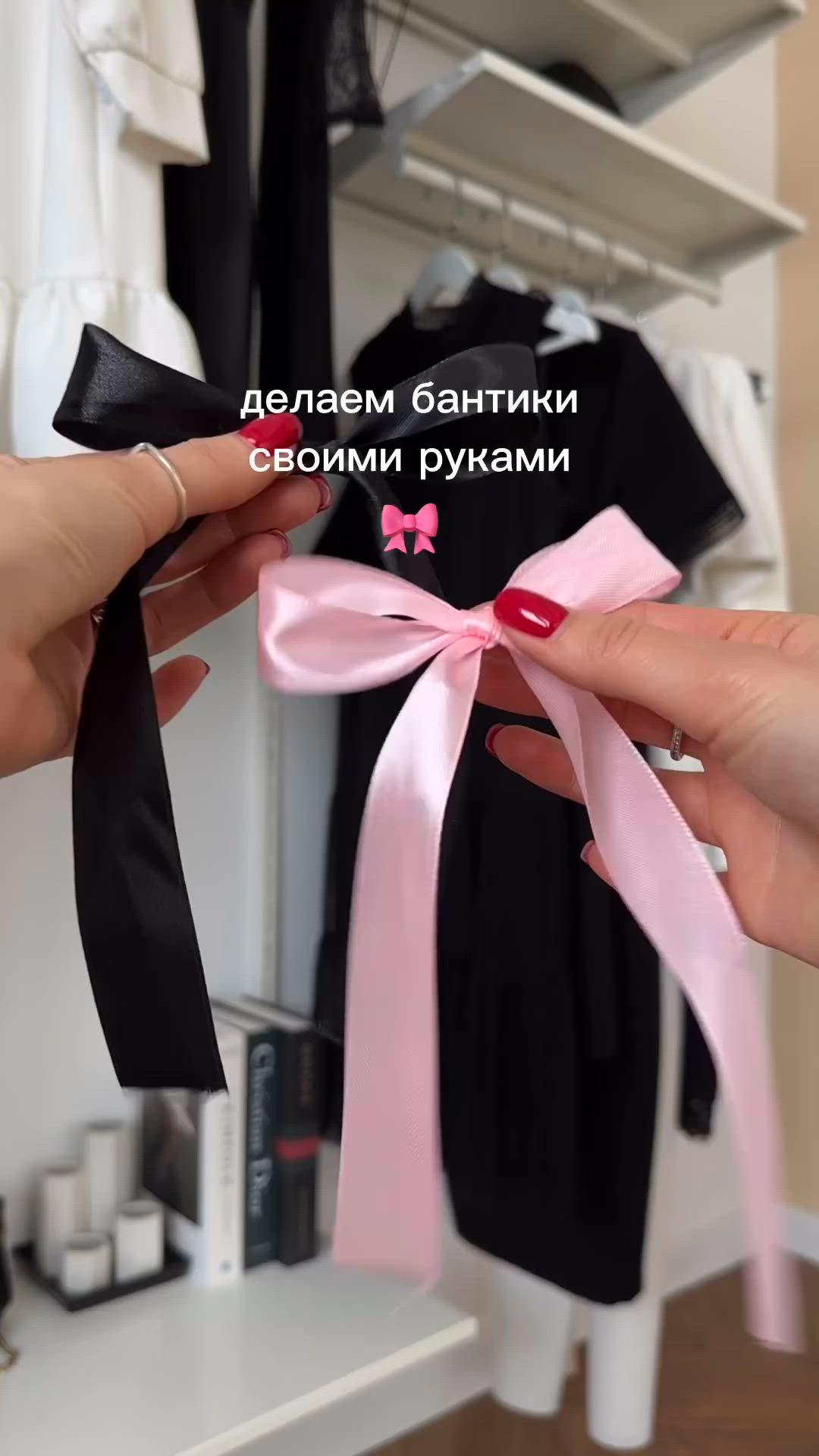 This may contain: two hands are holding a pink and black bow