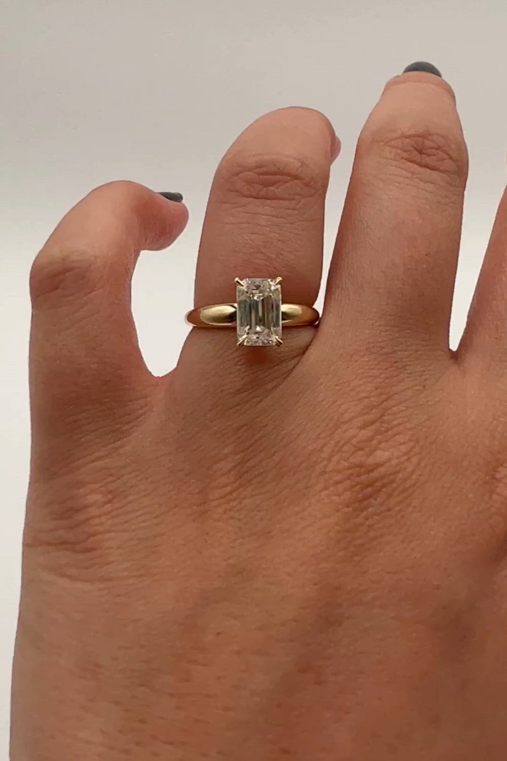 This may contain: a person's hand with a ring on it and a diamond in the middle