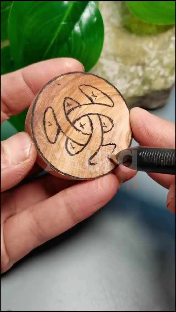 This may contain: a person holding a piece of wood that has been carved into the shape of a knot