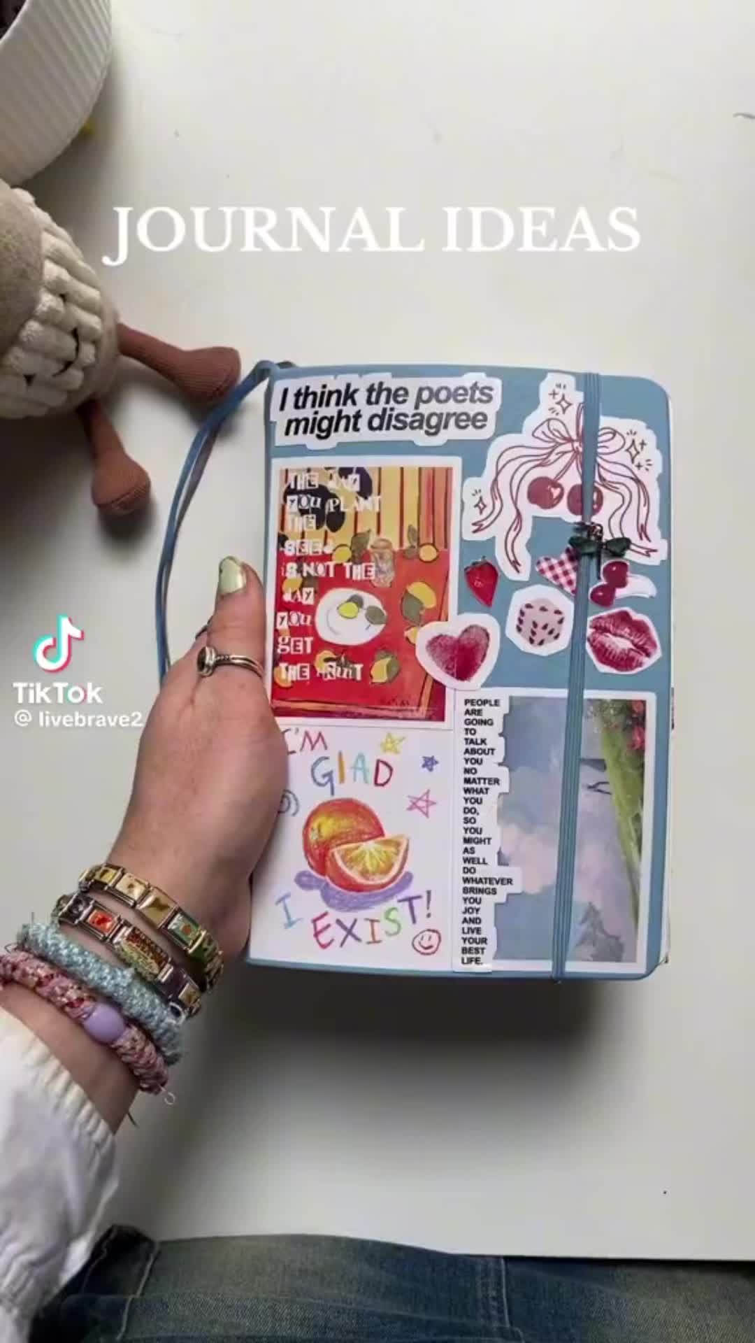 This may contain: a person is writing on a book with many different things in it and the words journal written