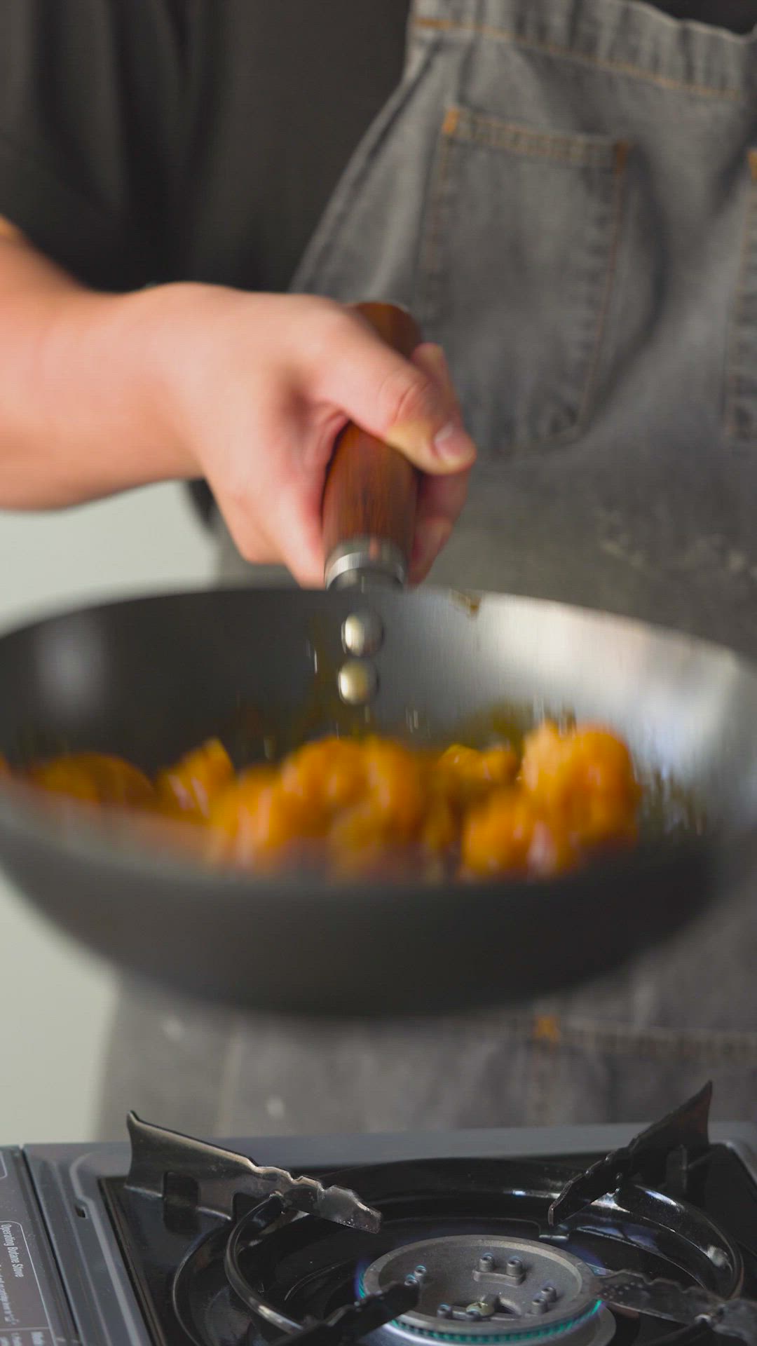 This may contain: a person cooking food in a frying pan on top of a gas burner