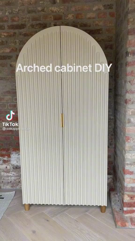 This may contain: an arched cabinet diy in front of a brick wall