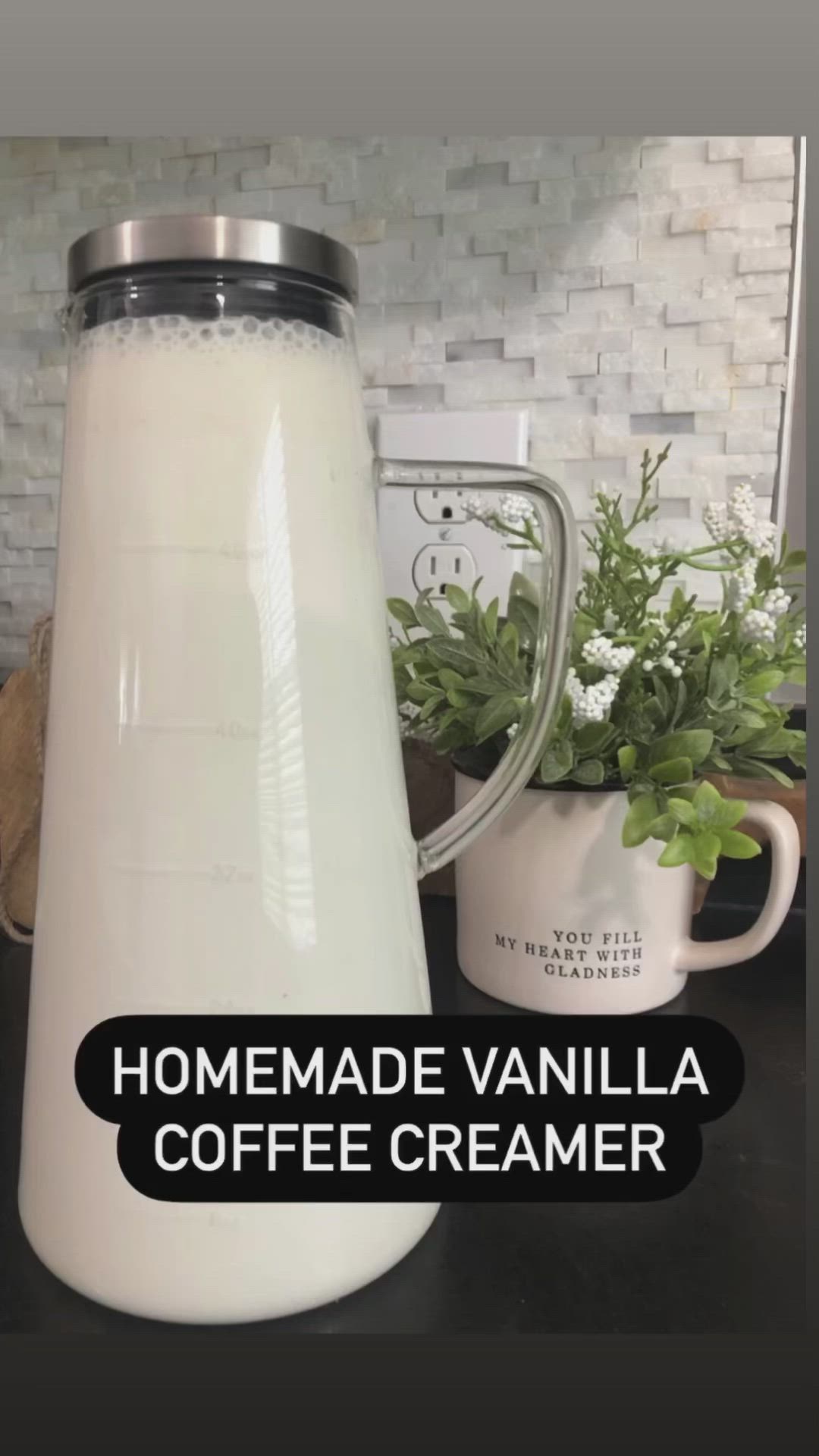 This may contain: a white pitcher sitting on top of a counter next to a cup and potted plant