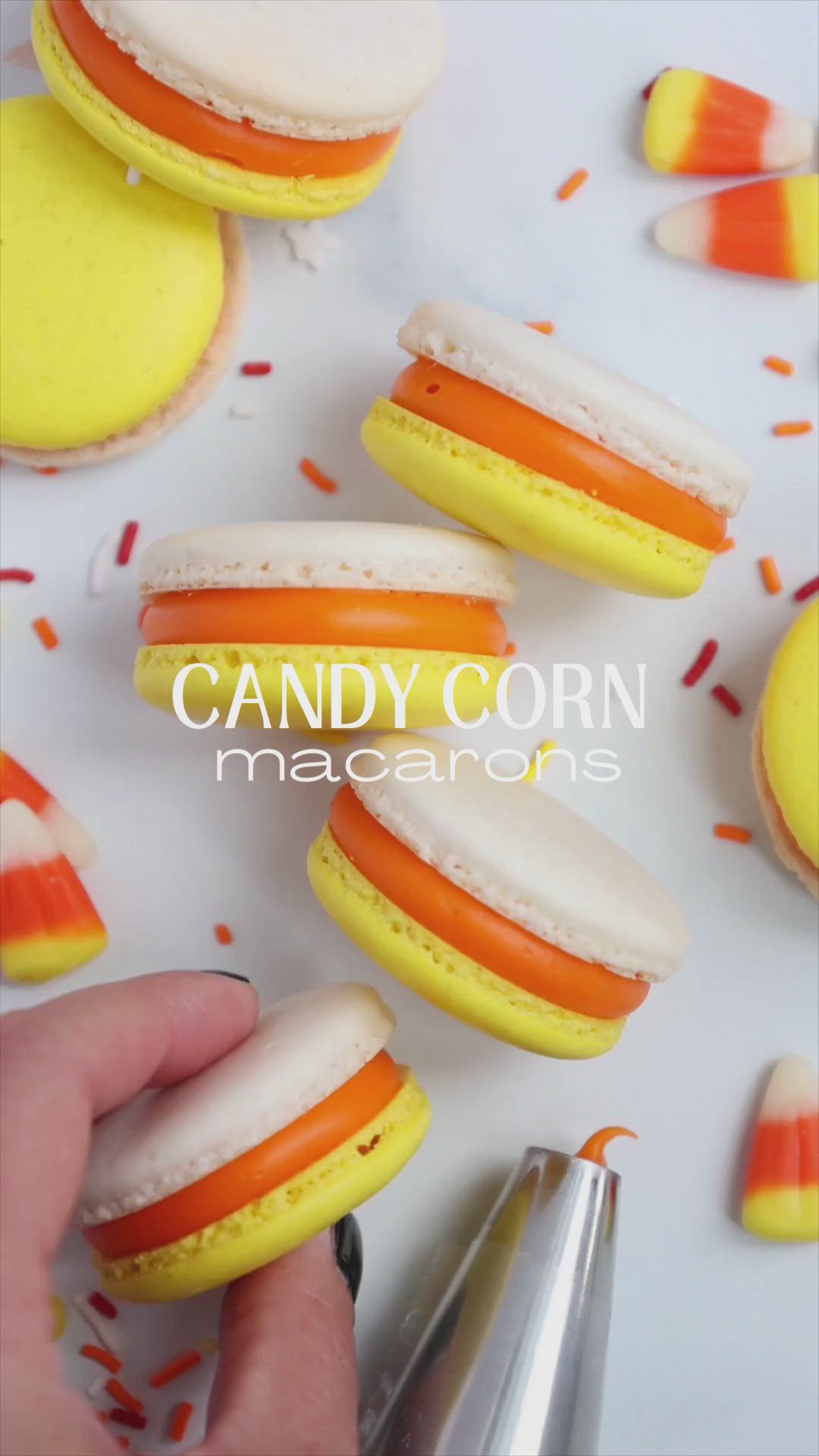 This may contain: candy corn macaroons with orange and white frosting