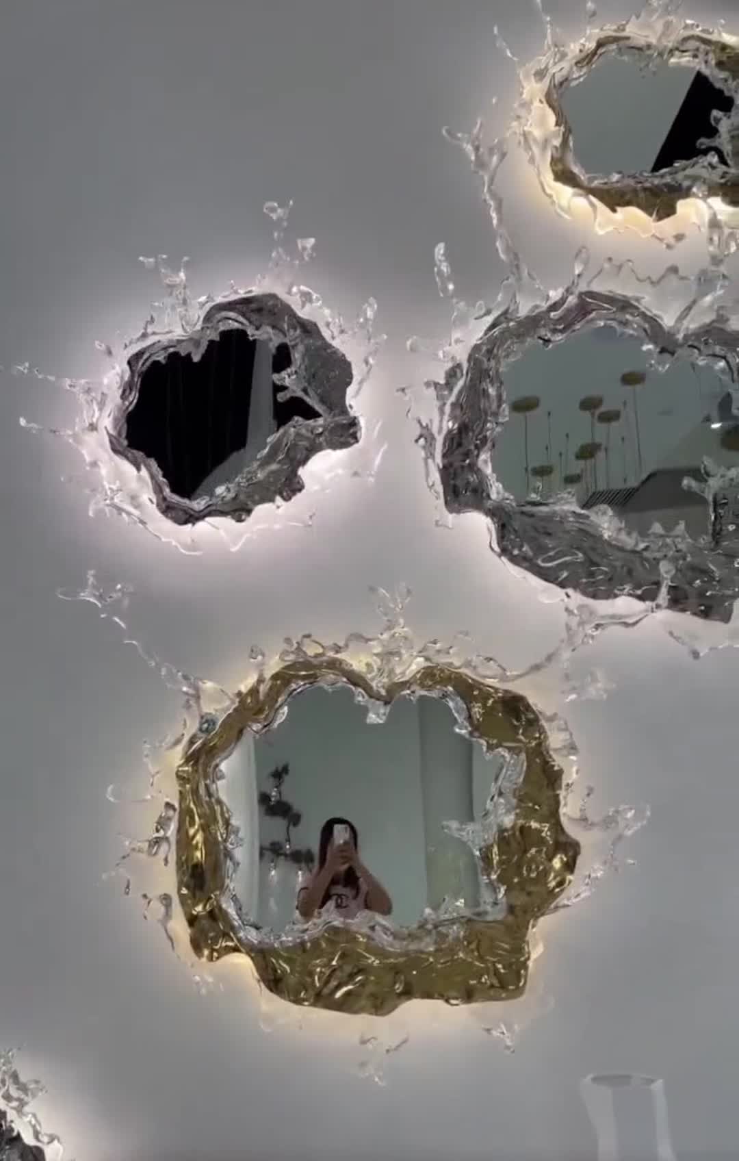 This may contain: the reflection of a woman in a mirror is seen through some water droplets on the ceiling