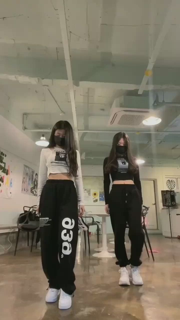 This may contain: two young women wearing black and white pants with the word'geo'printed on them