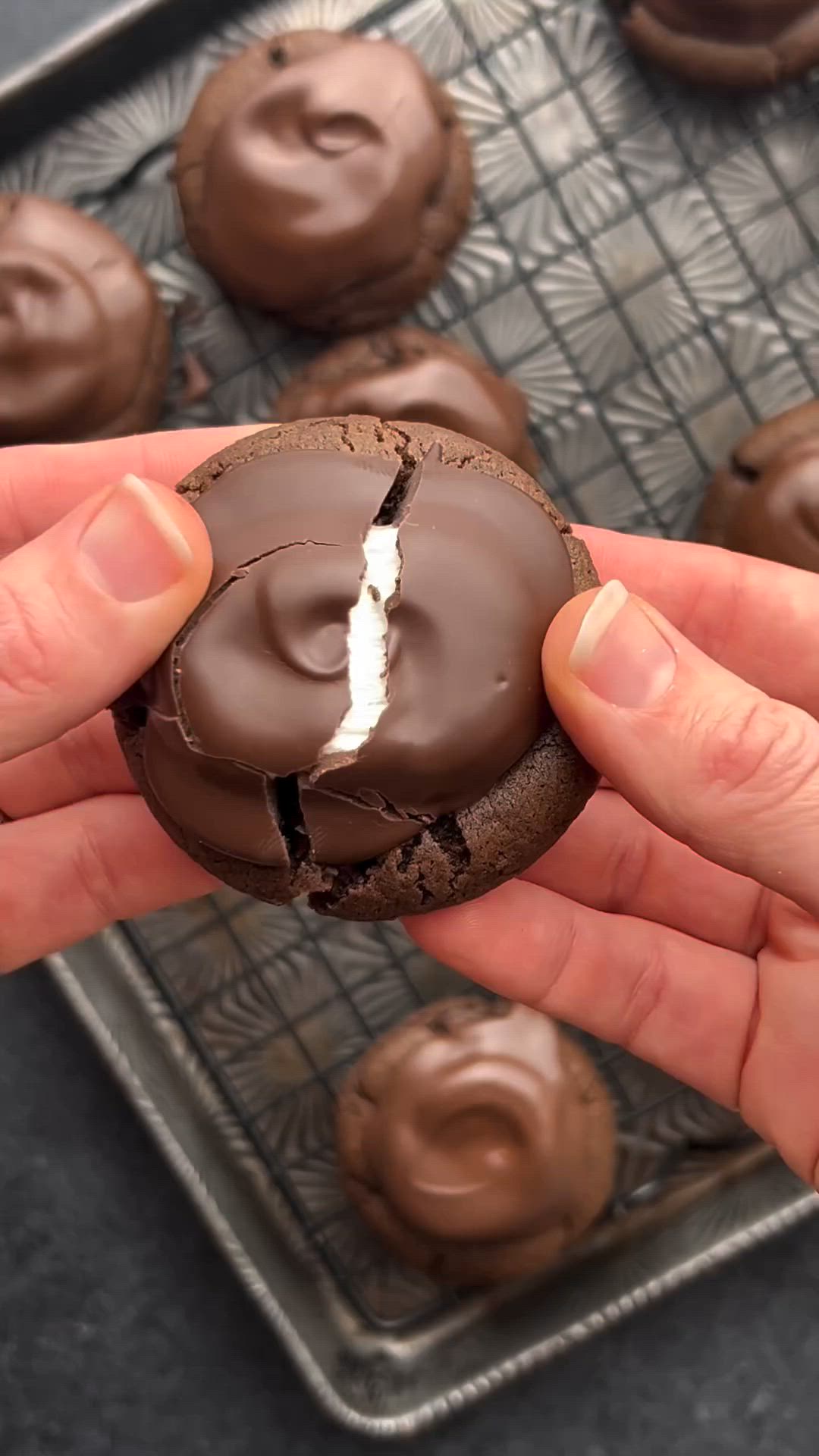 This may contain: chocolate cookies with marshmallows and chocolate frosting stacked on top of each other