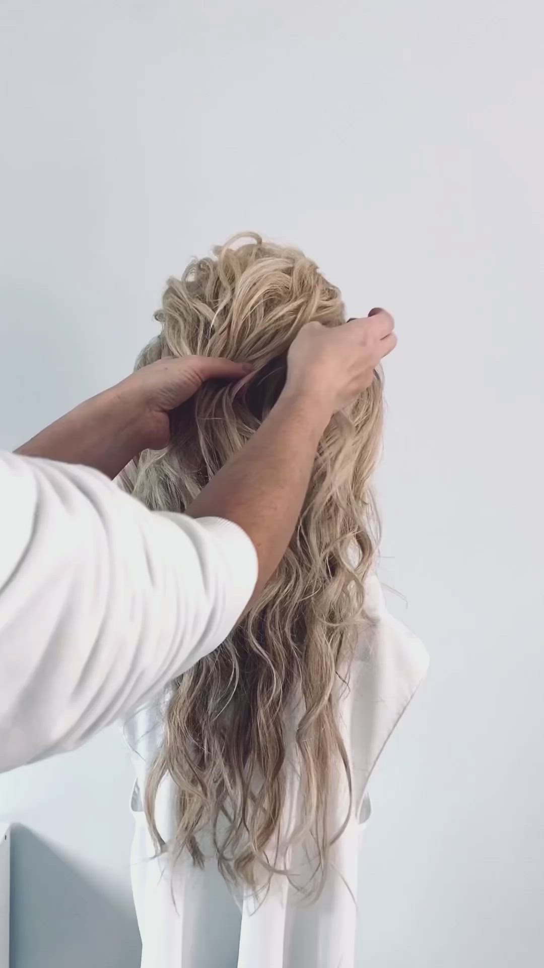 This contains an image of: How to turn a half up faux braid into an updo