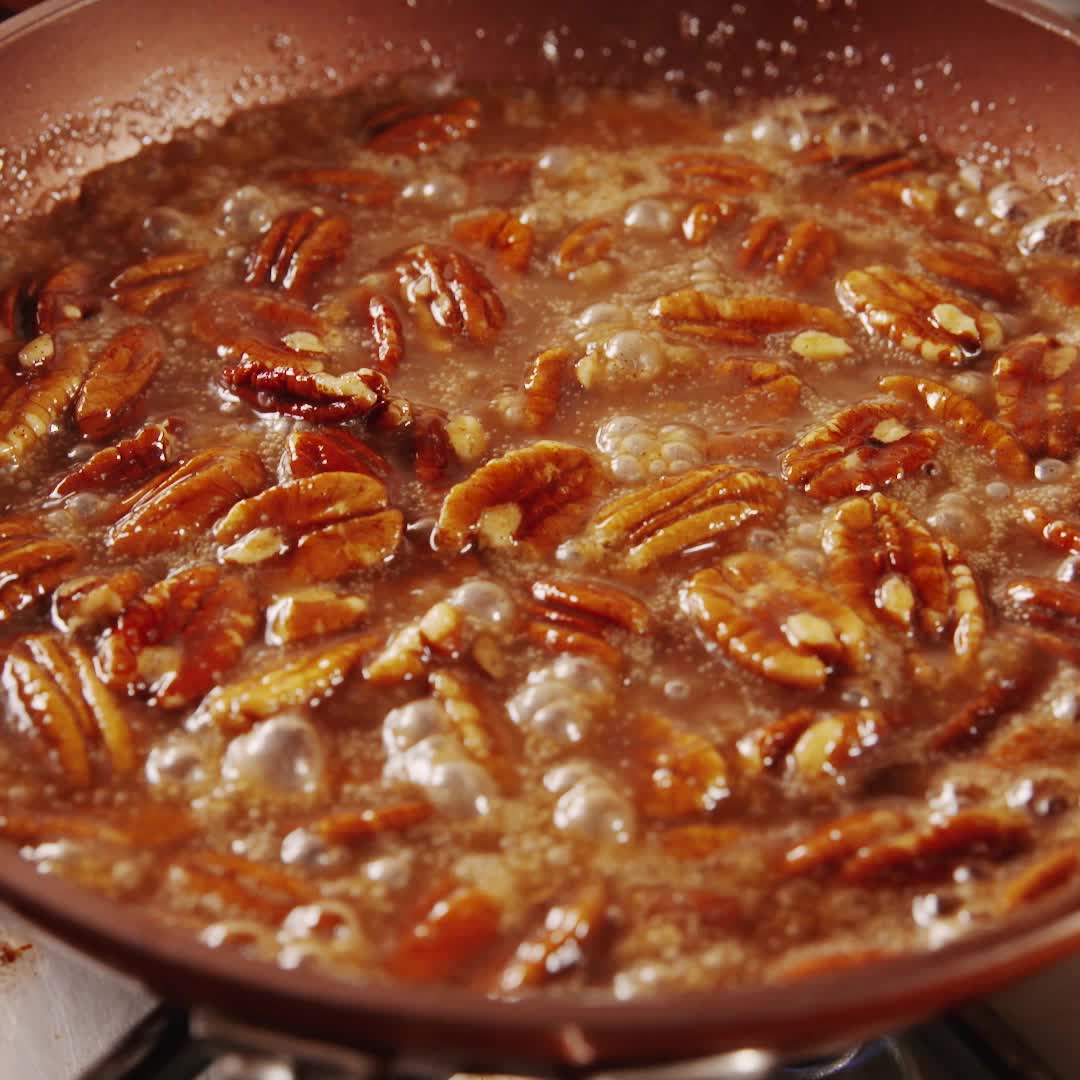 This may contain: pecans frying in a pan on the stove