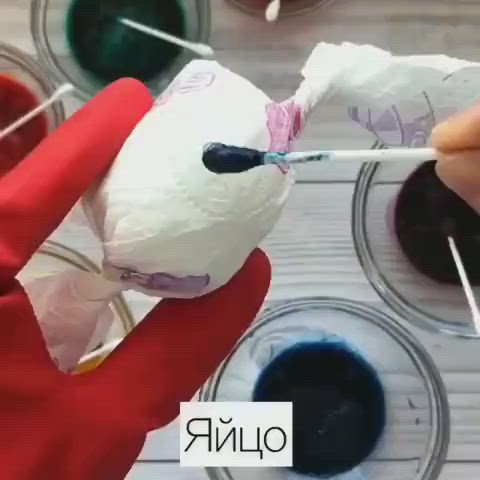 This may contain: someone is painting an easter egg with colorful dyes in the process of making it